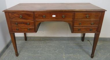 A 19th century mahogany kneehole dressing table/desk, the configuration of cock-beaded drawers above