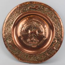 A large embossed copper charger, 19th century. Decorated with the tree of life to the centre