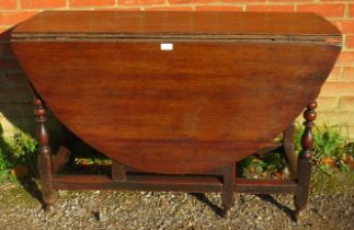 An 18th Century Oak oval drop-leaf gate leg dining table, with single drawer, raised on turned and