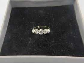 An 18ct yellow gold five stone graduated collet set brilliant cut diamond ring, size N/O. Centre