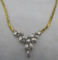 An 18ct yellow & white gold delicate necklace. The centre design having leaf decoration and set with