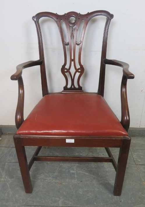 A Georgian mahogany elbow chair in the manner of Chippendale, having carved and pierced back,