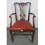 A Georgian mahogany elbow chair in the manner of Chippendale, having carved and pierced back,