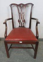 A Georgian mahogany elbow chair in the manner of Chippendale, having carved and pierced back,