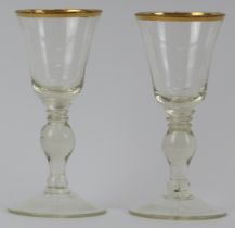A pair of European glass wine glasses, probably early 19th century. Both with gilt rims and