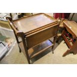 An oak tray top tea trolley with folding sides.