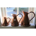 A graduated trio of copper jugs