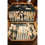 A art deco design wooden canteen containing an unused selection of plated cutlery.