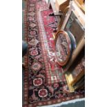 A large room sized woven woollen floor carpet , central geometric field, flanked by flower head etc,