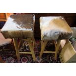 A pair of square top animal hide bar stools.