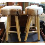 One square top and one round top animal hide bar stools.