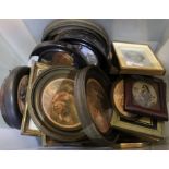 A crate containing pot lids and small sized pictures.