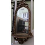 A 19th century gilt framed arch topped mirrored backed hanging display shelf. 62 cm width.