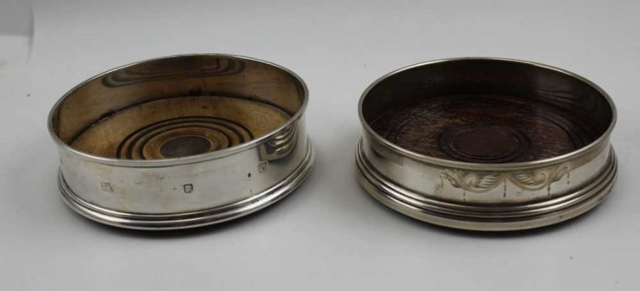 Two Georgian design silver bottle coasters, with turned wood bases, both late 20th century