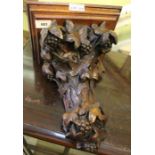 A carved wooden wall bracket with grape and vine decoration. 31 cm in length.