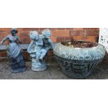 A Verdigris patinated planter with two small garden statutes.