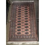 A late 20th century Pakistani pink ground hearth rug. 94 x 152 cm.