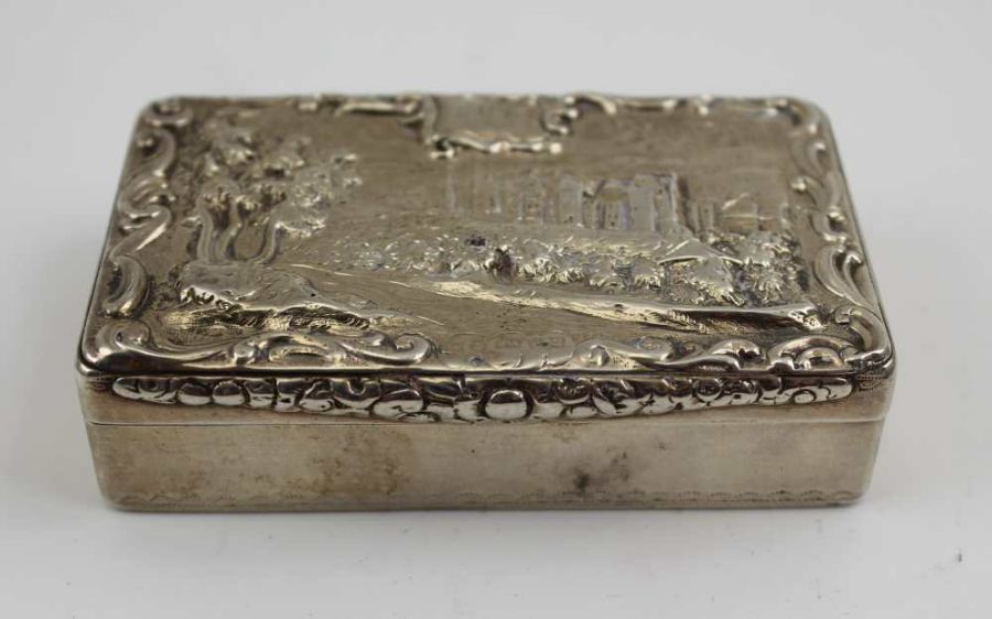 A William IV silver snuff box, the hinged cover decorated with a raised image of a grand country hou