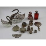 A silver mounted cut glass swan with articulated wings, a similar smaller one, various scent bottles