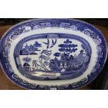 A large 19th century Willow pattern platter, a Pentax camera, two cast metal insurance plaques and a