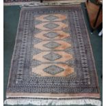 A probably North Indian woven woollen floor rug, central geometric forms within multiguard borders