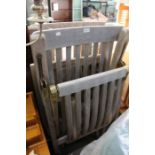 A pair of weathered teak garden chairs with green cushions.