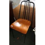 A retro designed metal framed chair with laminate wooden seat