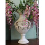 A Classic design resin urn together with decorative artificial flower arrangement
