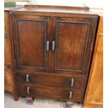 A dark oak tallboy, two cupboard doors over two drawers