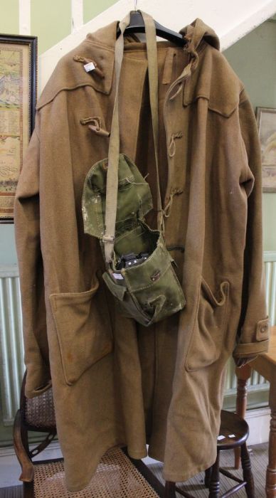 A second World War probably Naval cold weather duffle coat with a bagged gas mask.