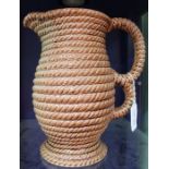 A large early 20th century brown glazed jug with rope work decoration.
