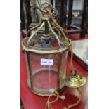 A brass hanging lantern with glass shade