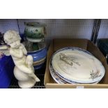 A selection of pottery serving platters, a cast seated cherub, a pottery planter and a table luster.