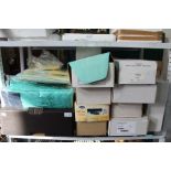 A shelf containing bagged and unused bedding and a large selection of boxed ladies shoes