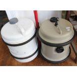 A pair of rolling water barrels for camping.