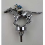 A mid to late 20th century car mascot, chromed metal and painted as a cantering jockey, 8.5cm high