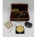 A collection of decorative powder compacts, and a quizzing glass, in a carved wood box, 21.5cm wide