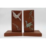 A pair of terracotta bookends, with moulded and glazed geese decoration, 16cm high