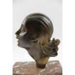 An Art Deco ornament, formed as a cast metal profile of a young woman, inscribed "Trevoli" raised up