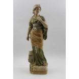 A Royal Dux porcelain figurine, young Classical woman in a gilt blushed green gown, pink factory mar