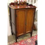 An Edwardian mahogany two door free standing music cabinet. 95cm high excluding upstand.