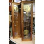 Two clocks, within wooden cases (some parts in white tub)