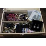 A wooden box containing costume jewellery.