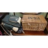 A wicker picnic hamper with drinking glasses with a picnic rucksack.