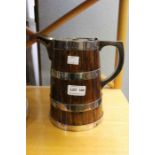 A wooden jug, silver plated hoops of barrel form, with hinged cover