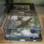 A cased model of a B17 Bomber on a WWII memorial flight with a D-Day Experience book.