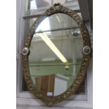 An oval gilt framed fancy scroll mirror with miniature inserts