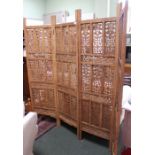 A folding carved four panel wooden room screen.