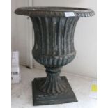 A cast iron campagna form garden urn, remains of green painting ,50cm high