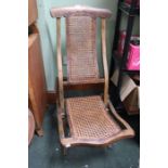 Early 20th Century folding steamer chair with cane work back and seat.
